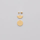 Pair of earrings with half-circle and circle pendants on a plain background.