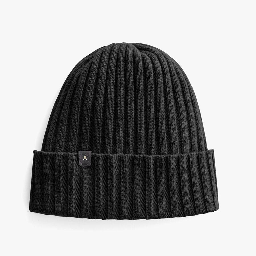 Ribbed beanie with folded cuff and small tag marked A.