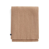 Folded ribbed blanket with a label on white background.