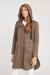 Woman in a hooded jacket standing with hands visible