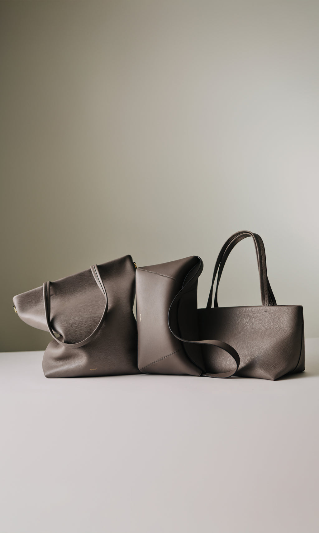 Three handbags arranged on a flat surface.