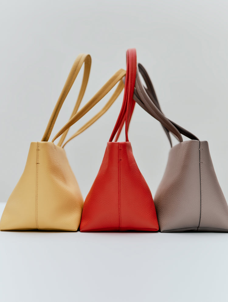 Three handbags with shoulder straps arranged side by side.