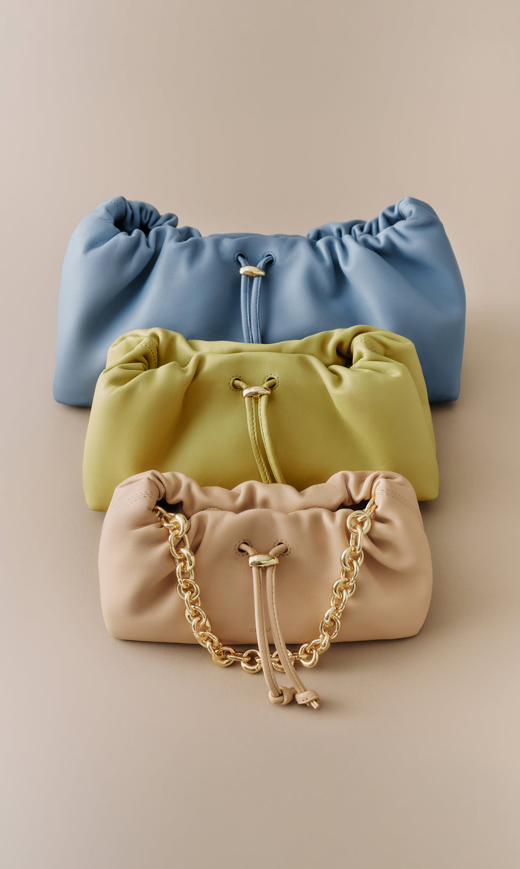 Three drawstring bags stacked, bottom one has a chain handle.