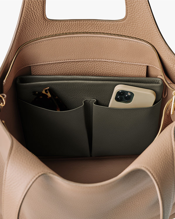 Open handbag with phone and sunglasses in pockets