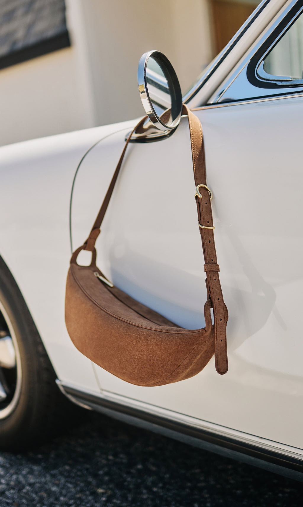 Bag hanging on a side mirror of a parked car.