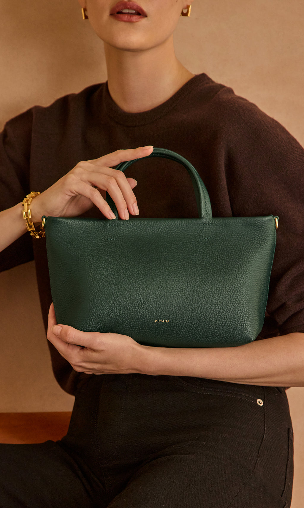 Person holding a handbag with one hand on the handle