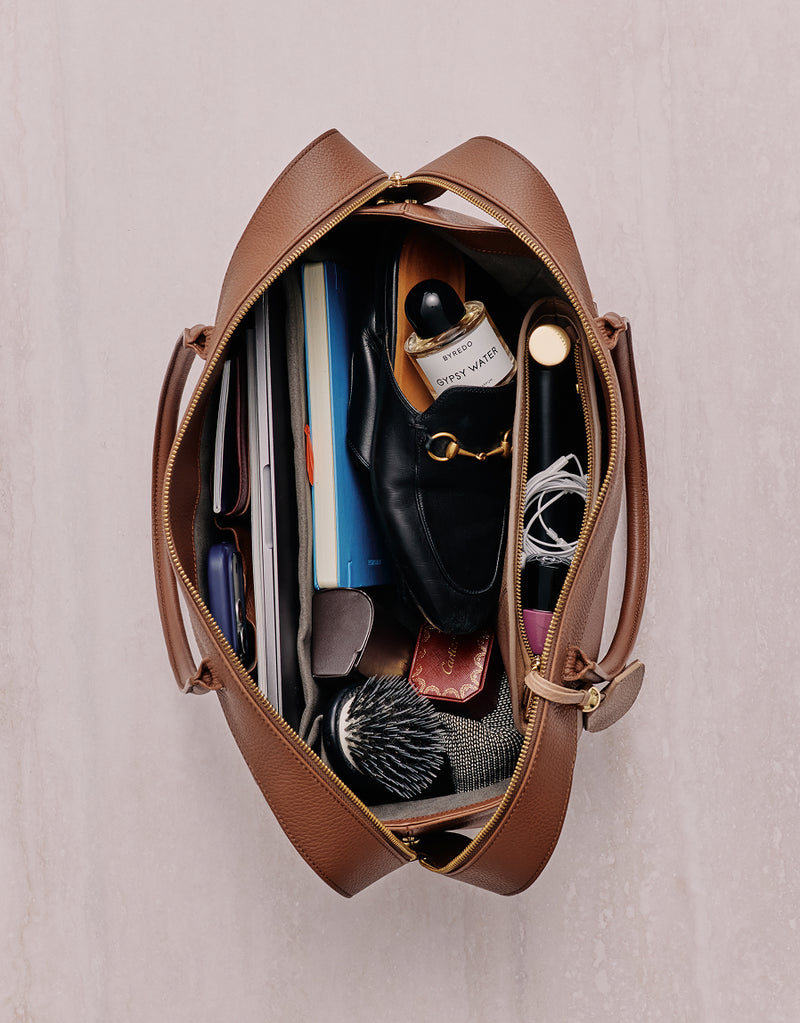 Open travel bag with various items neatly arranged inside
