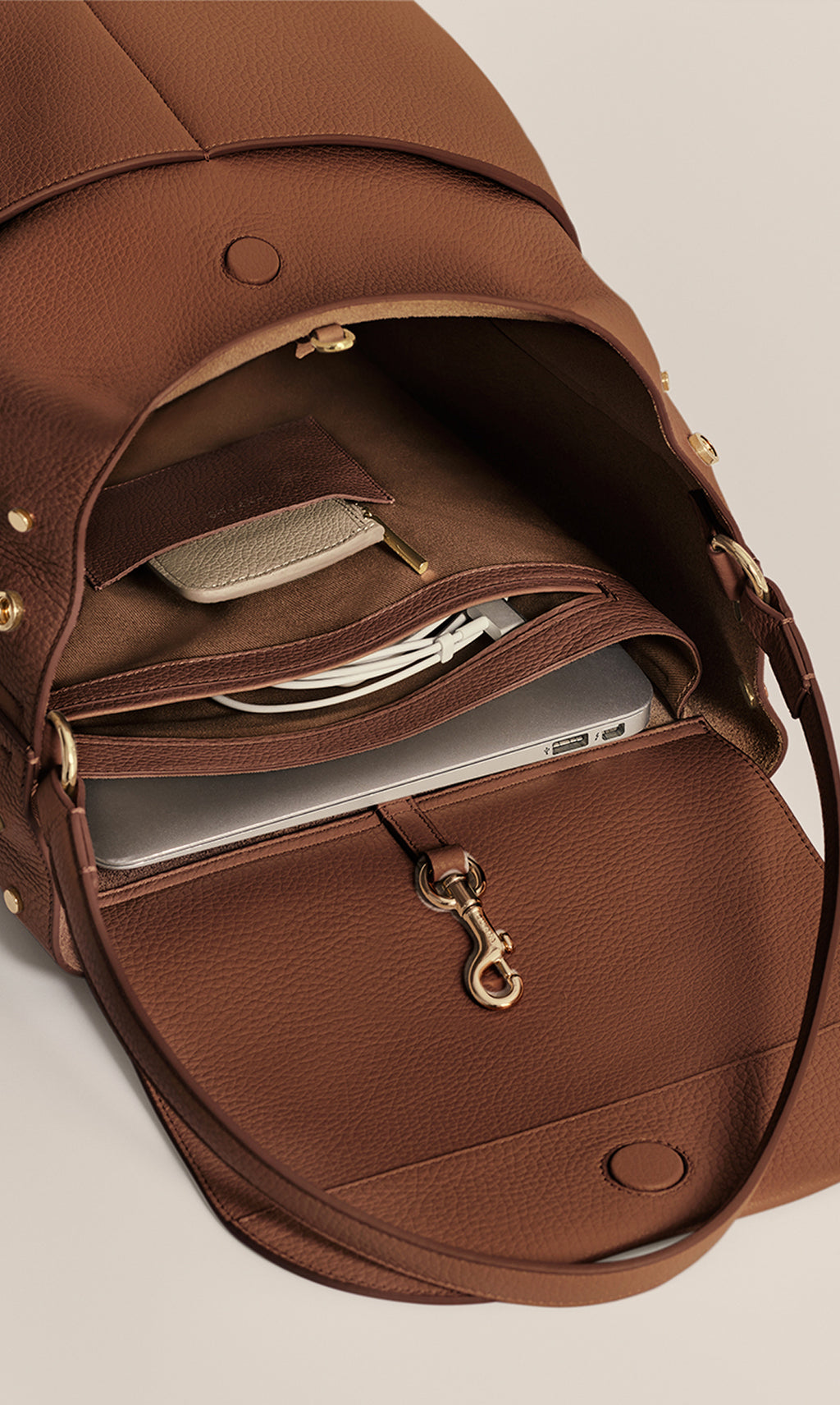 Open travel bag showing laptop, pouch, and key hook inside.