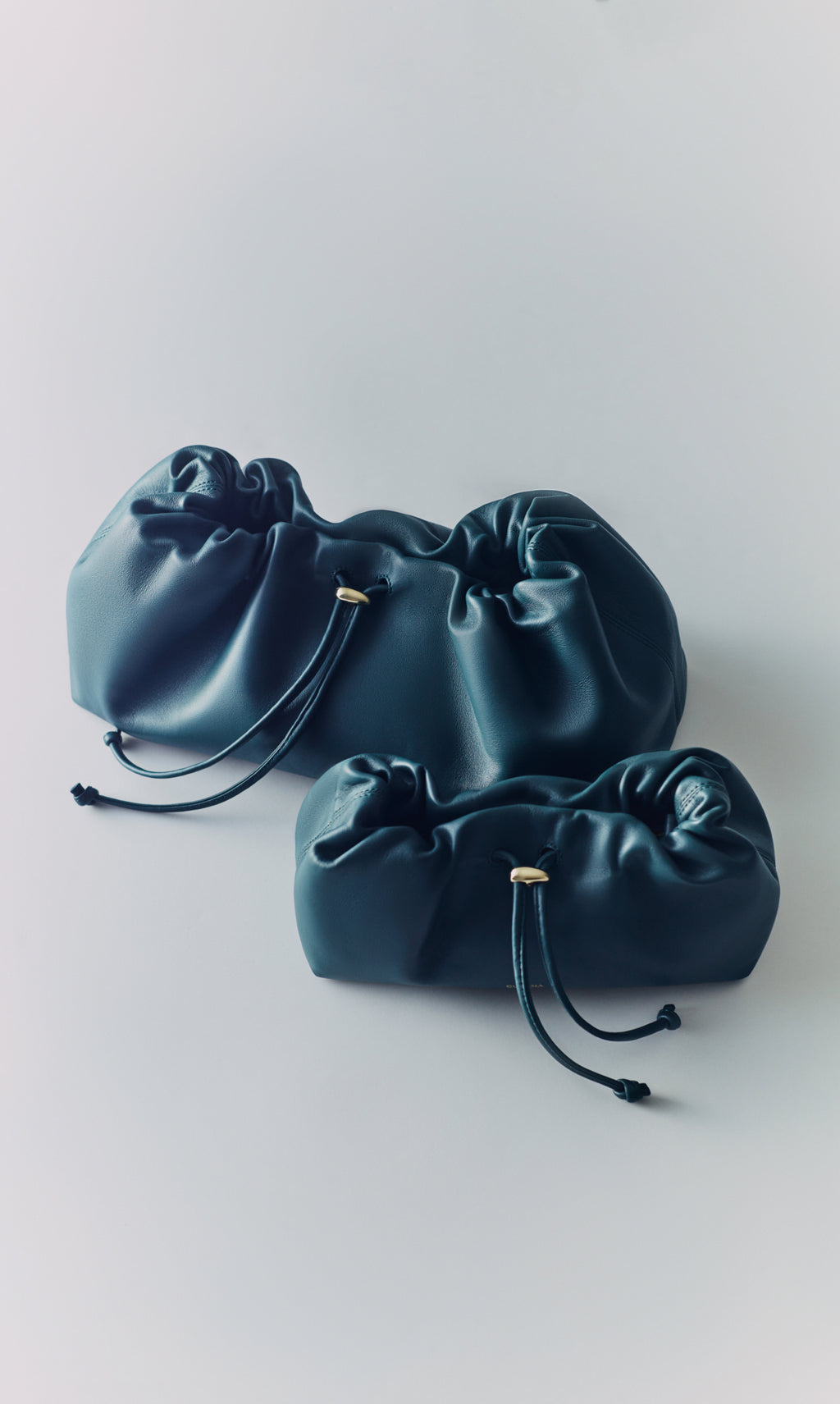 Two soft drawstring pouches placed on a flat surface.