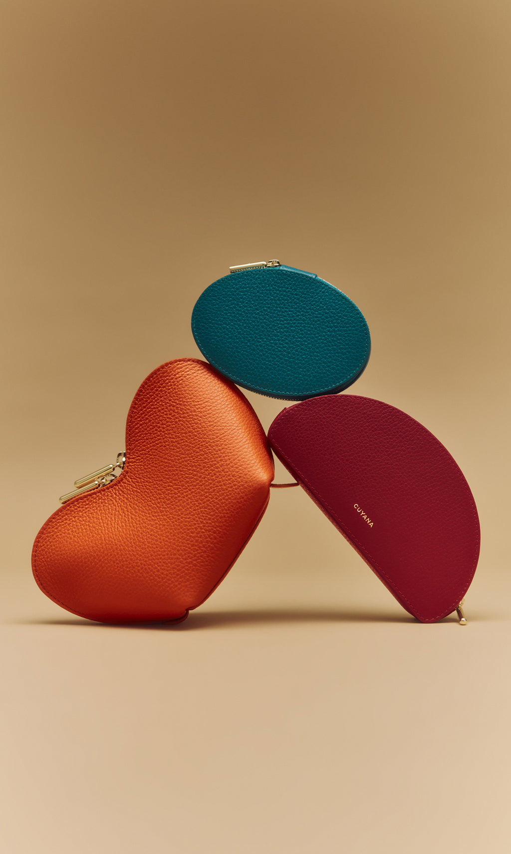 Heart-shaped and oval leather pouches stacked creatively.