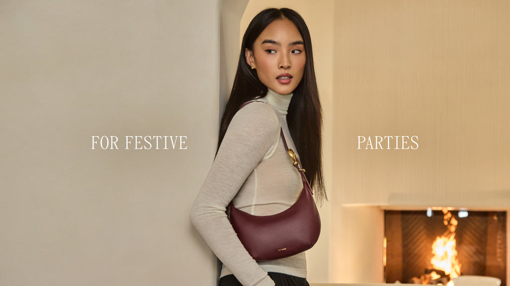 Model with shoulder bag standing by fireplace text for festive parties