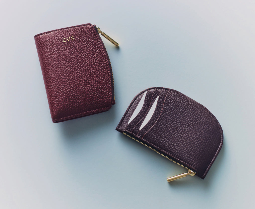 Two small textured leather pouches with gold zippers on a flat surface.