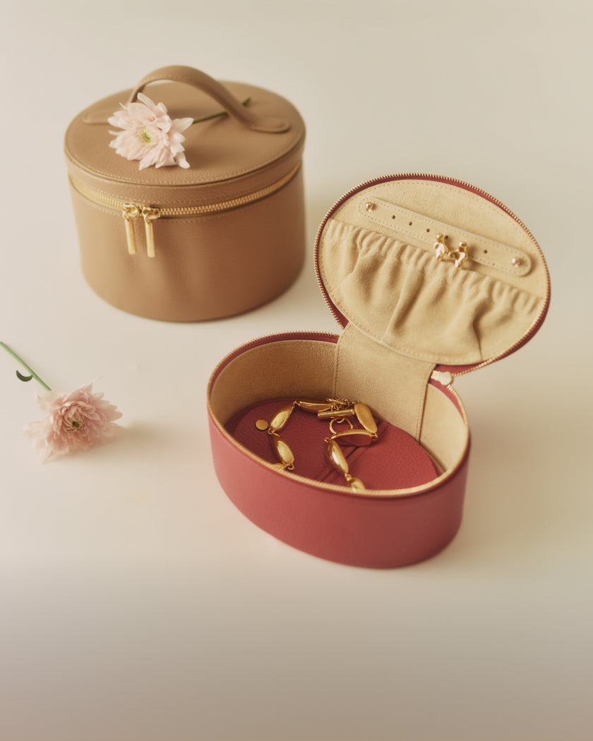 Round case with a flower on top and an open jewelry box with earrings.