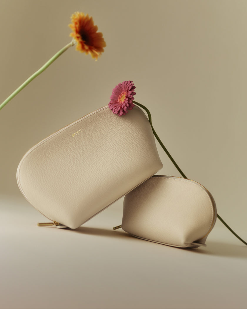 Two pouches with flowers in the background.