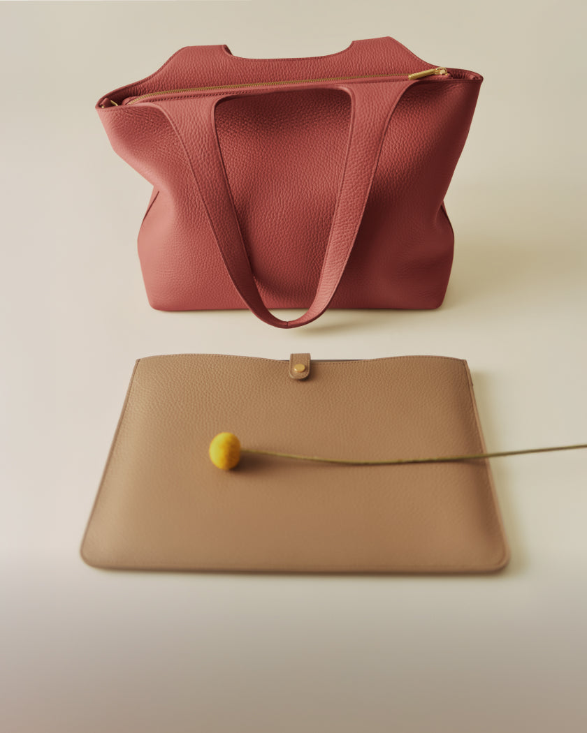 Travel bag and flat pouch with a flower stem attached.