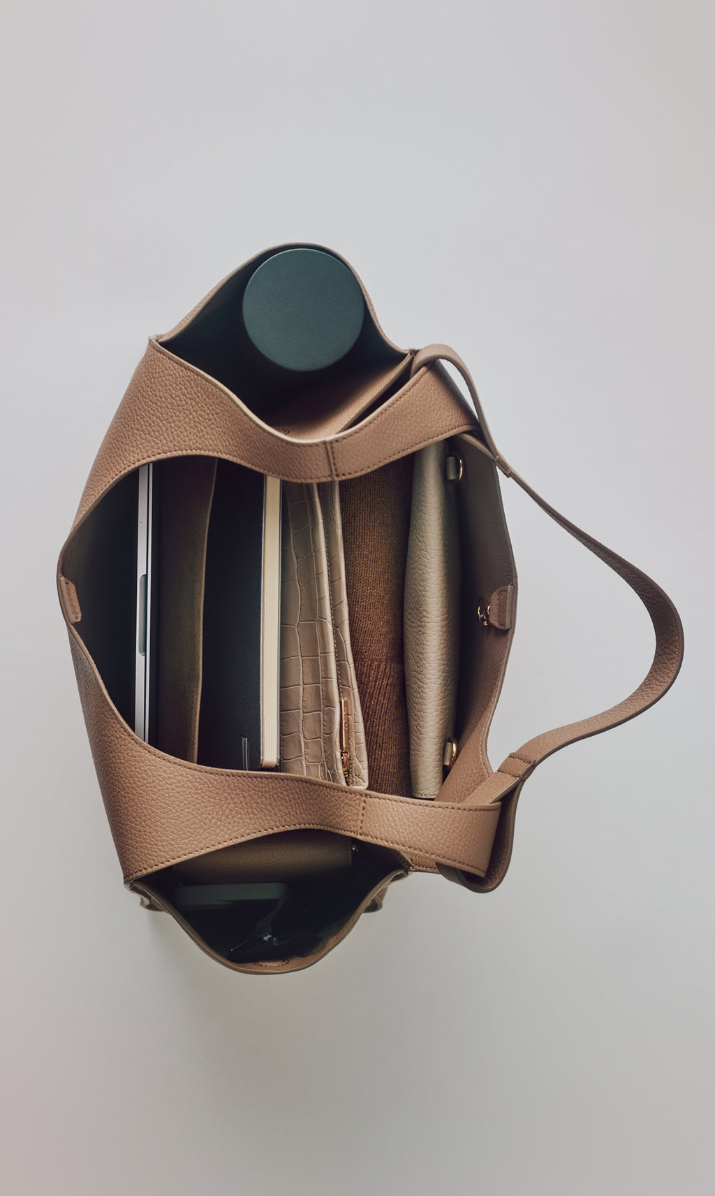 Open handbag containing a water bottle and organized folders.