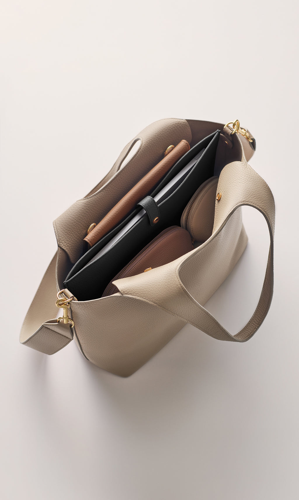 Open tote bag holding several items including a laptop and notebooks.