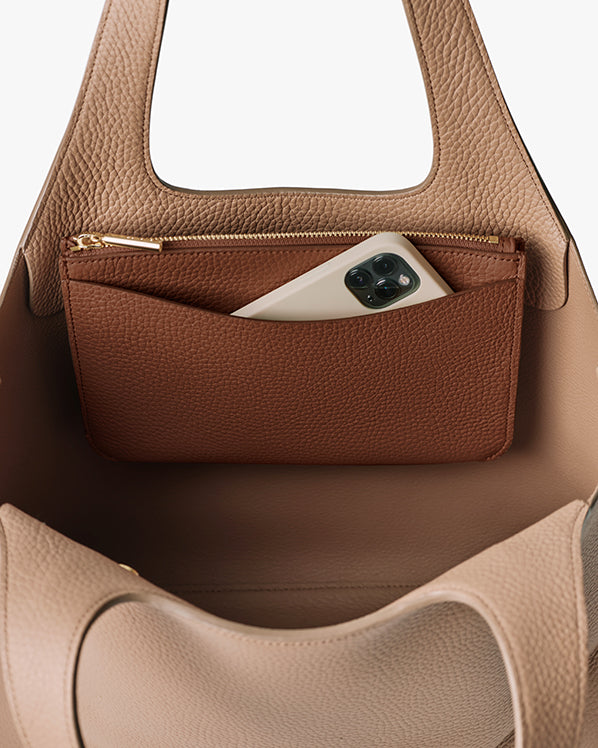 Open handbag with phone in interior pocket.