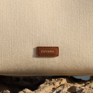 Bag with stitched leather label placed on a rocky surface.