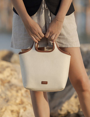 Person holding a tote bag outdoors.