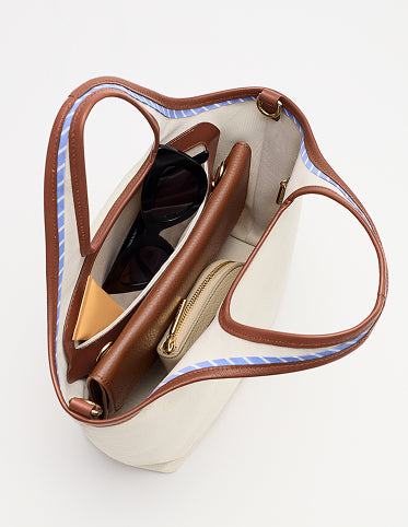 Open handbag with sunglasses and purse inside.