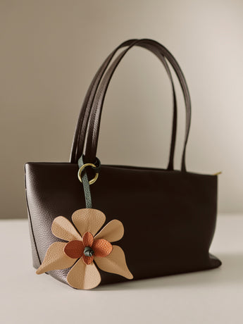 Handbag with a flower keychain attached to the handle