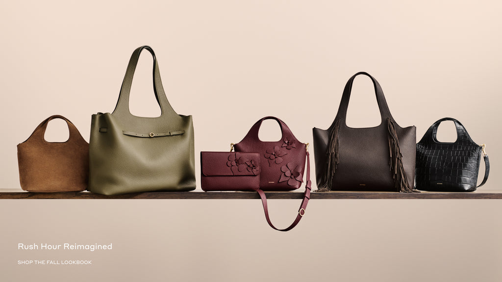 Six handbags of different styles are displayed on a shelf.