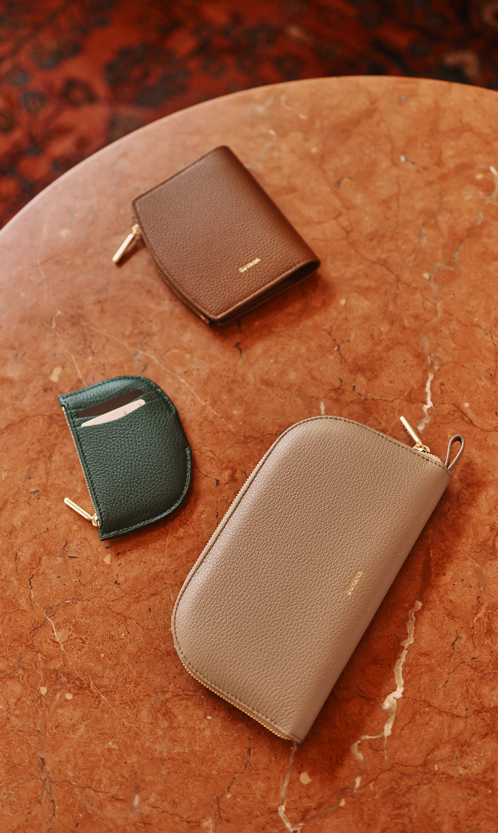 Three wallets on a marble surface.