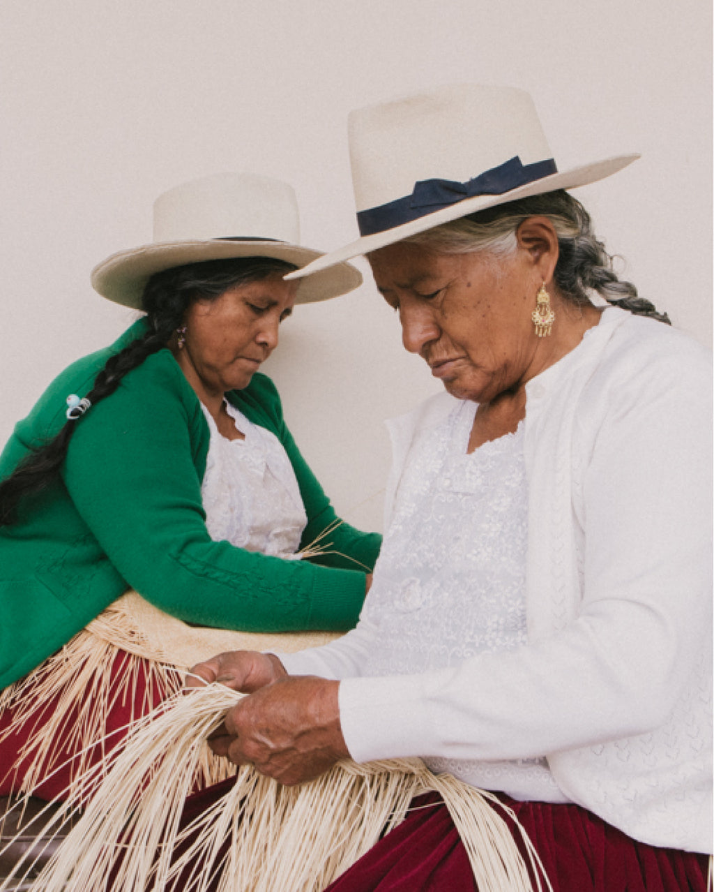 Two women weaving together.