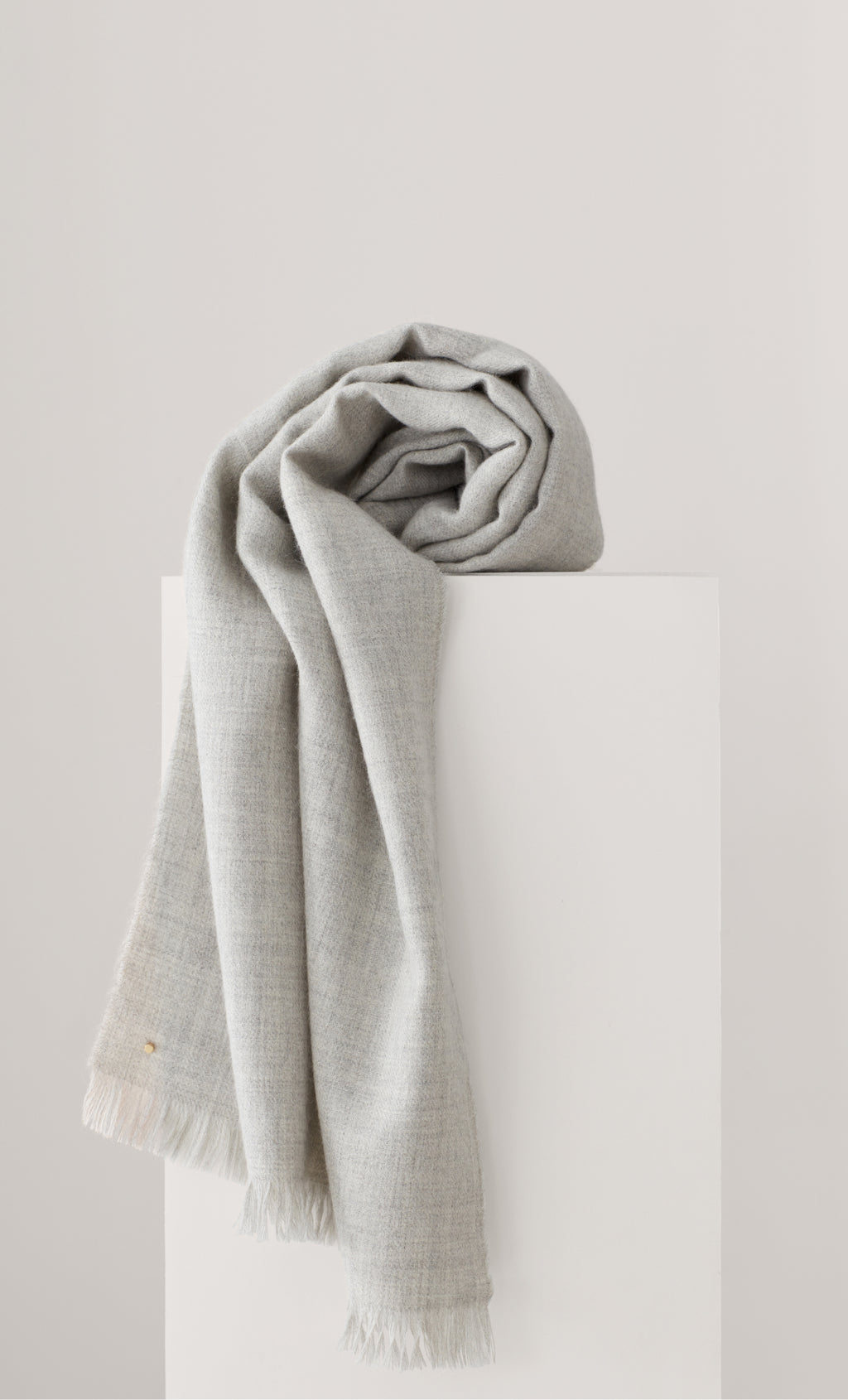 A folded scarf draped over a rectangular object.