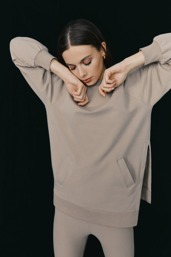 Woman in a relaxed pose with arms crossed and eyes closed.