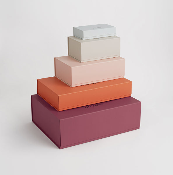 Stack of four closed boxes of different sizes placed on top of each other.