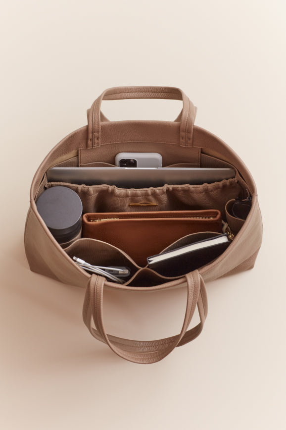 Open bag with various compartments containing personal items.