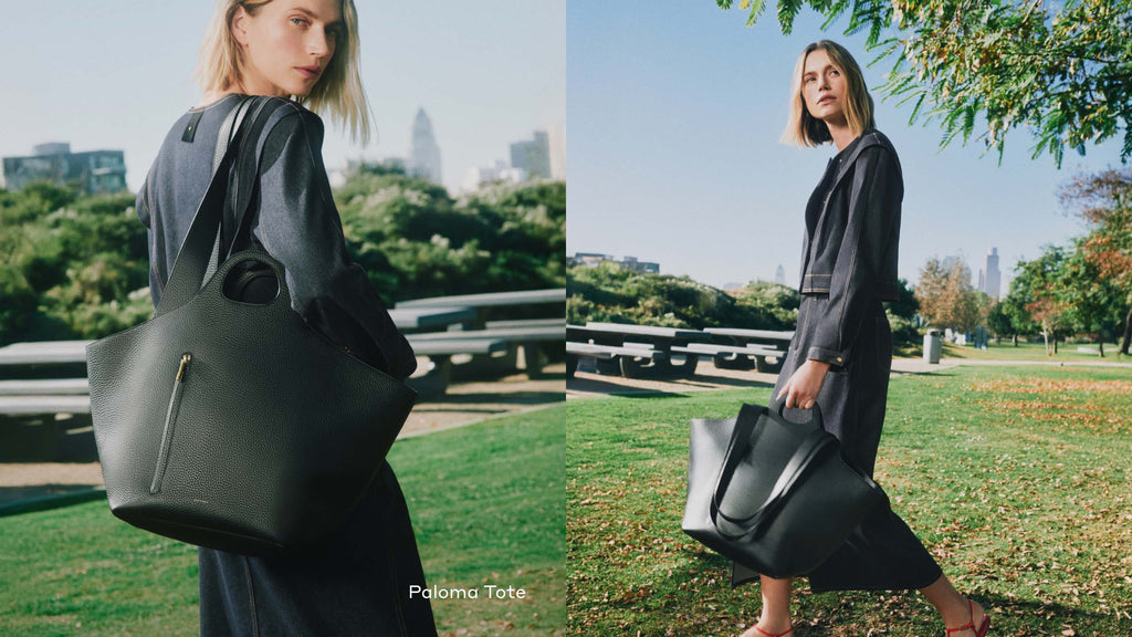 Woman outdoors holding large tote bag in park setting.