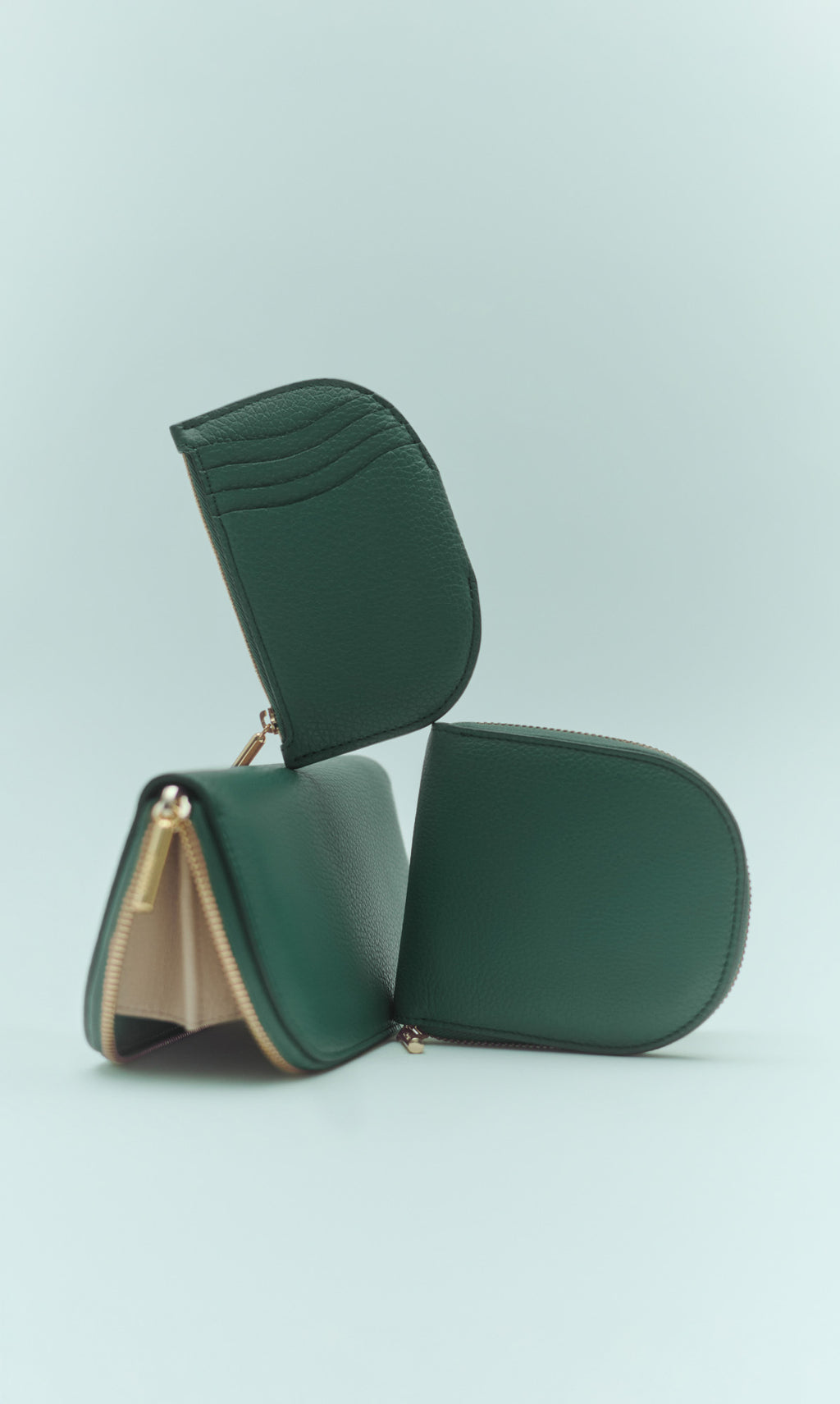 Stacked leather zip wallets arranged artistically against plain background