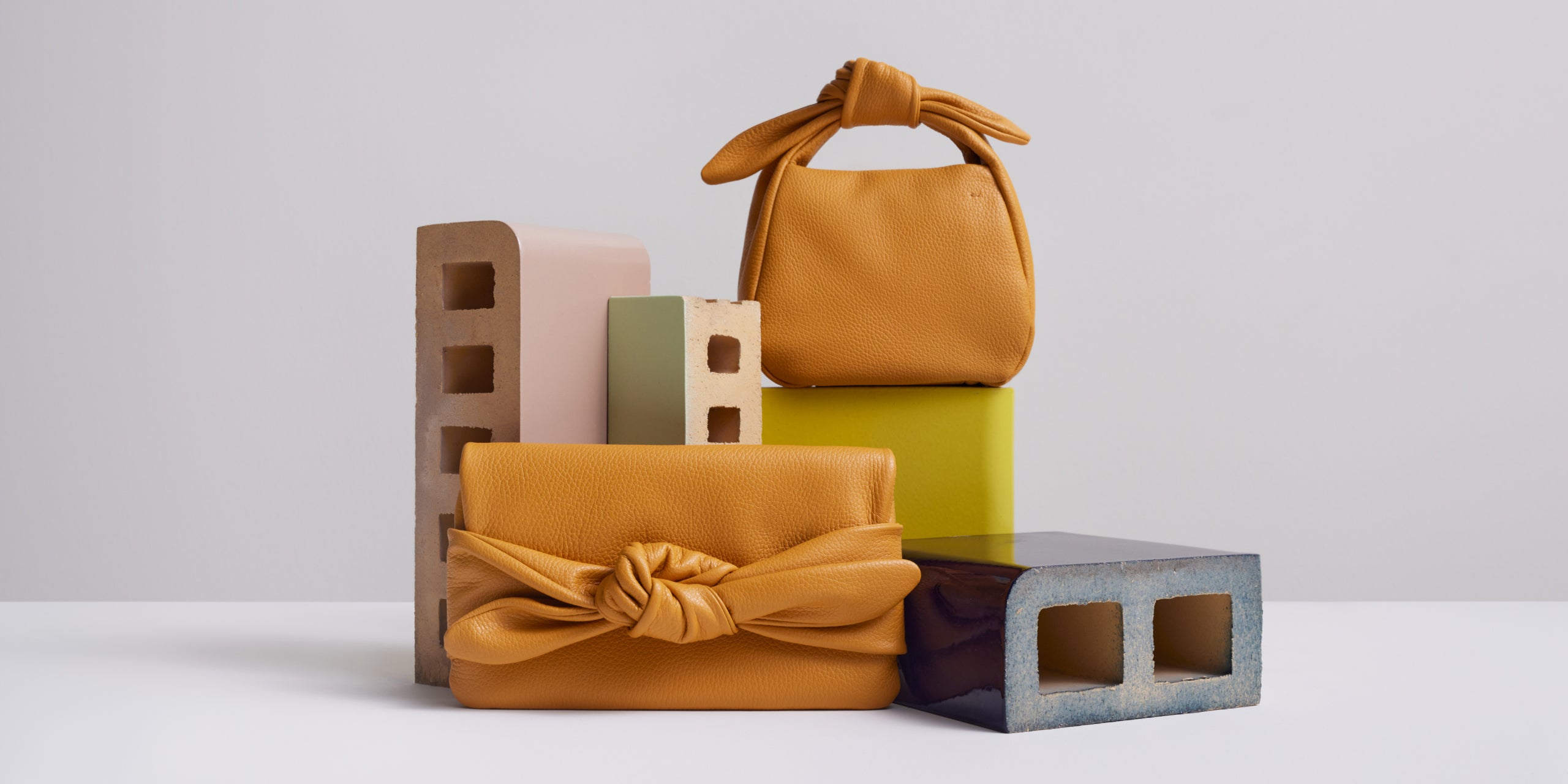 Arrangement of two handbags with assorted blocks on a plain background.