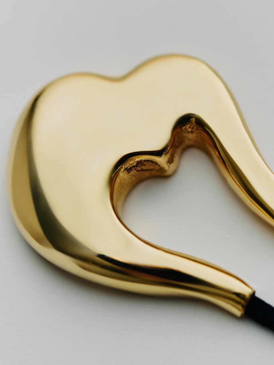 Abstract heart-shaped metallic object with a small cavity in the center