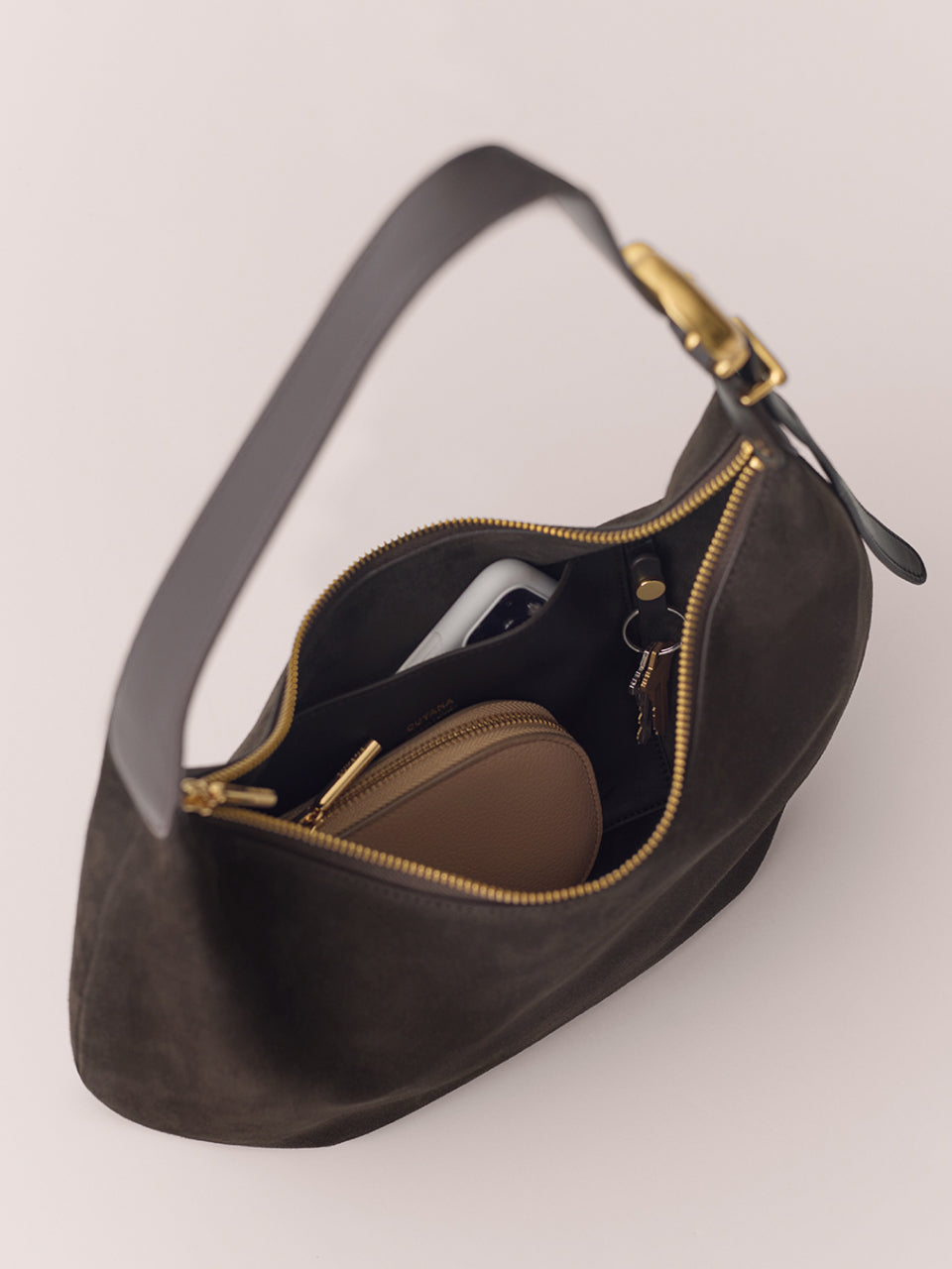 Open handbag showing contents like a wallet, phone, and keys.