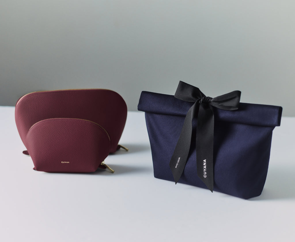 Two pouches, one with a ribbon and bow, on a plain surface.