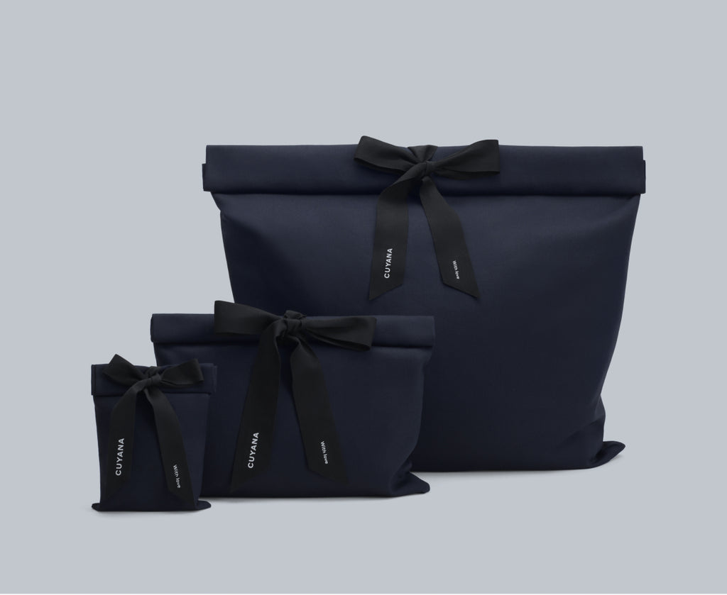 Three gift bags with bows in different sizes placed together.