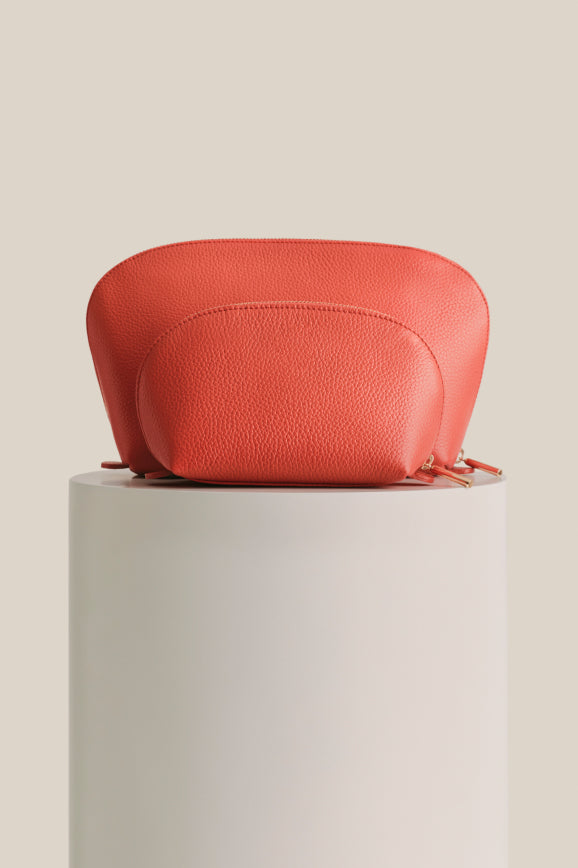 Small textured bag on a cylindrical pedestal.