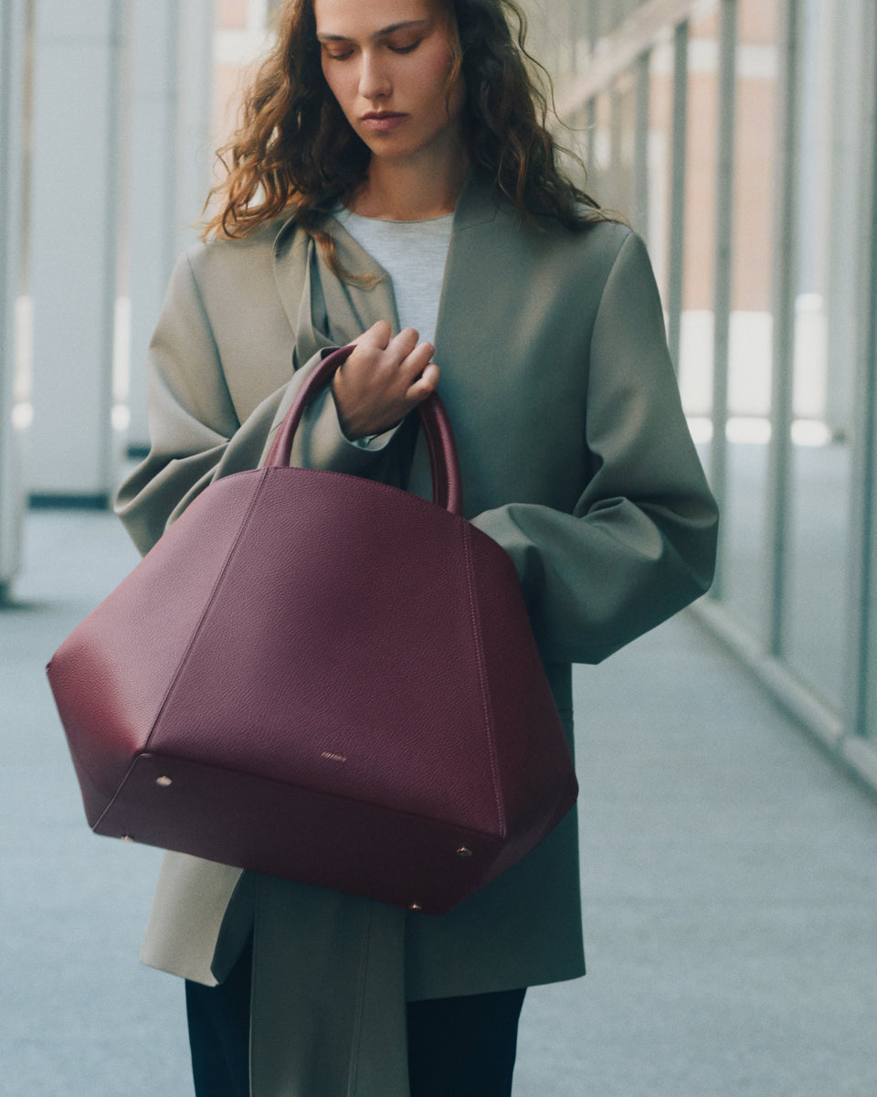 Person with a large handbag walking by glass windows