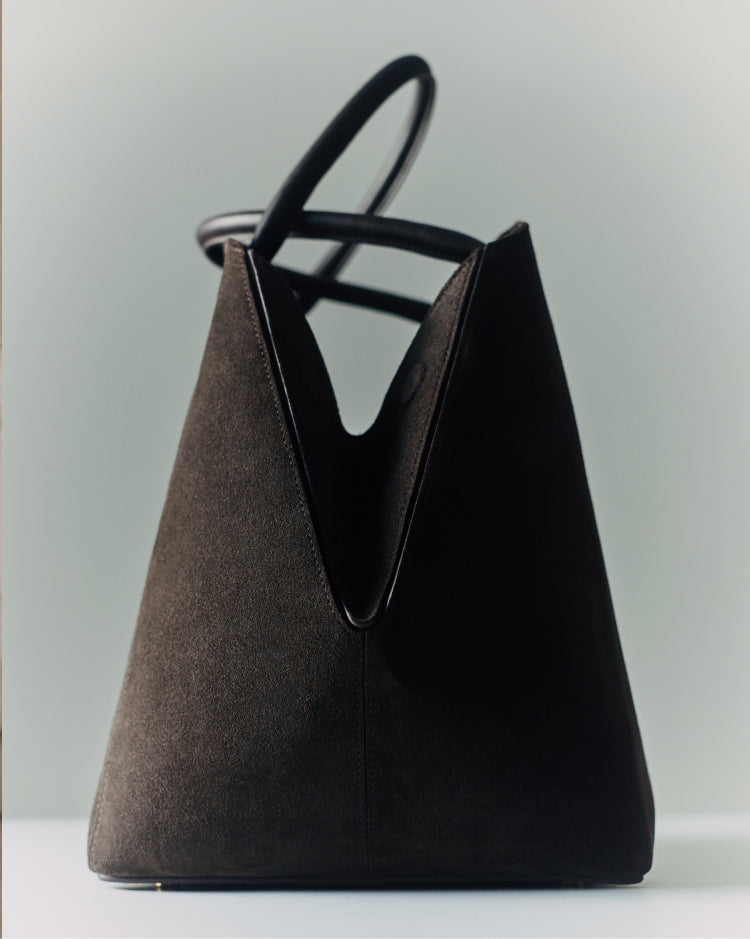 A geometric handbag with a single strap, standing upright on a flat surface.