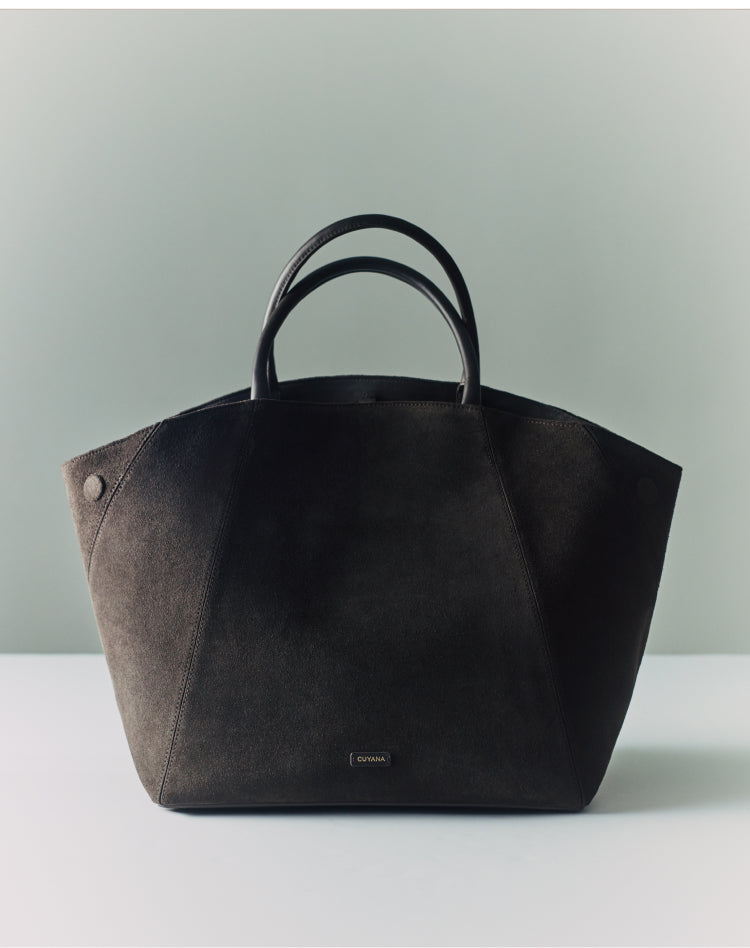 A large tote bag with short handles on a flat surface.