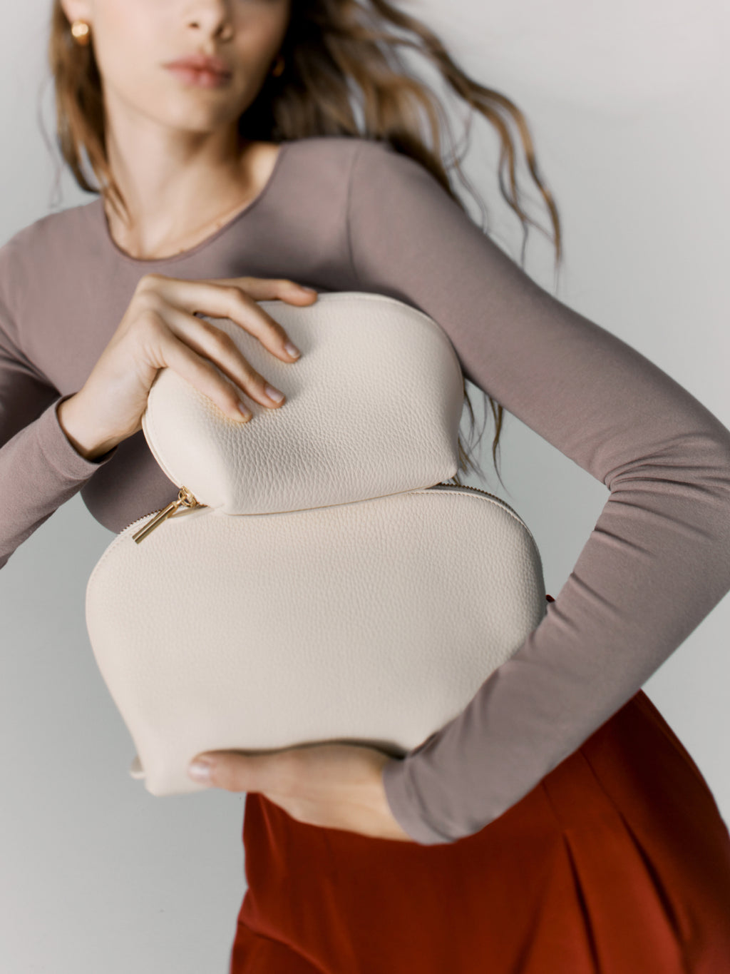 Woman holding a heart-shaped purse close to her body.