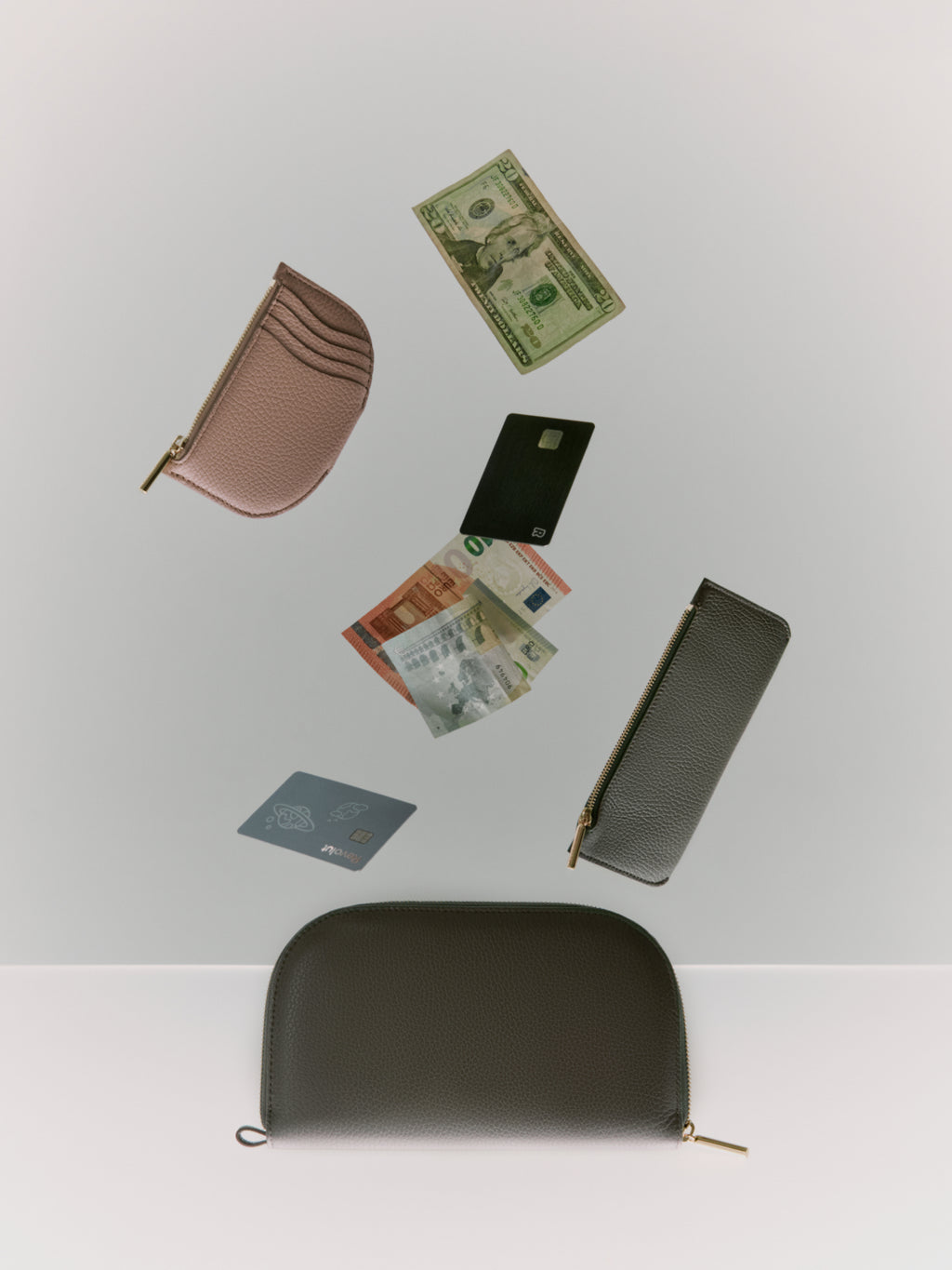 Wallets, money, and passports arranged in a floating layout against a light background.