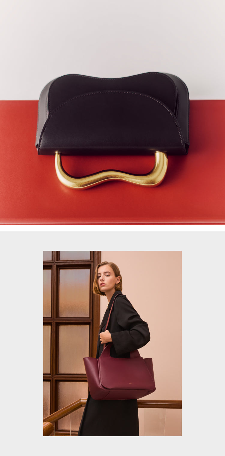 Elegant handbag with curved metal handle; woman holding large handbag indoors.