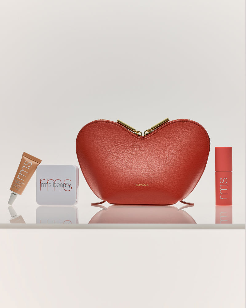 Heart-shaped bag with three makeup items on a shelf.