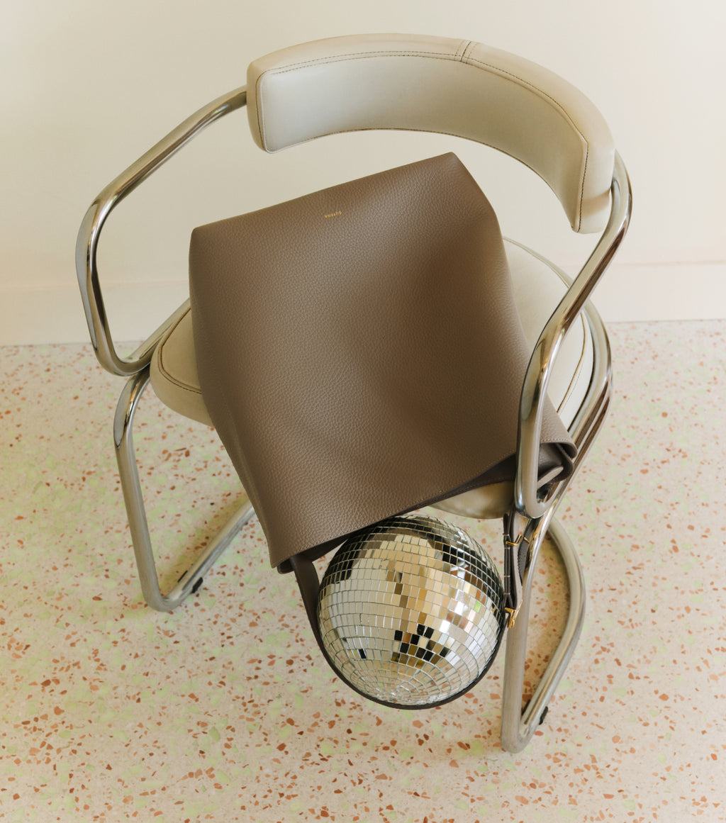 Modern chair with a large bag covering a disco ball on the seat.