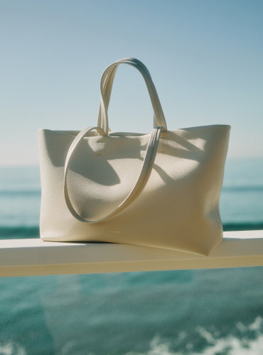 Tote bag on a ledge with ocean in the background.